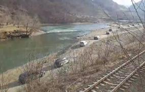 Video cu șoferi care circulă pe malul apei, pe Valea Oltului, din cauza unui accident. Ca să nu mai aștepte, oamenii au găsit "autostrada secretă"