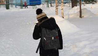 Copil cu rucsac în spate pe o vreme geroasă