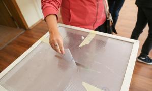 Alegătoare pune buletinul în urnă într-o secție de votare