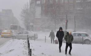 Oameni în zăpadă pe o stradă din Bucureşti