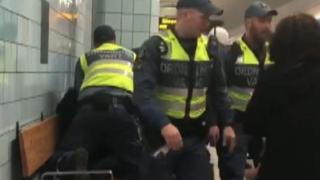 Femeia gravidă înconjurată de agenții de pază