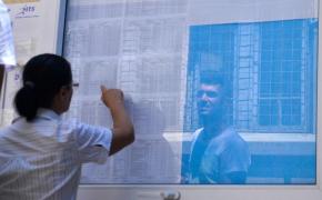 Femeie urmărește rezultatele la Bacalaureat