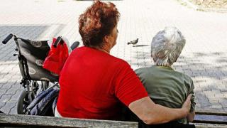 Îngrijitoare alături de o bătrână din Italia