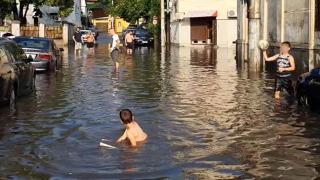 Copii se joacă pe strada inundată