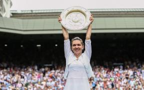 Simona Halep arată trofeul câștigat la Wimbledon