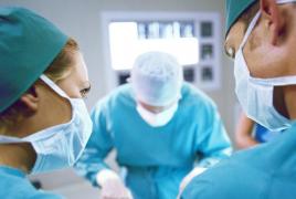 Medicii operează un pacient în sala de operaţii