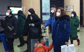 Oamenii care poartă măști de protecţie de față se plimbă pe o stradă, în Beijing, China.