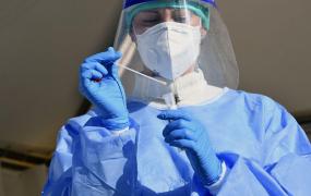 Medic care efectuează testul COVID-19