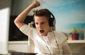 Băiat la calculator, cu căştile pe urechi