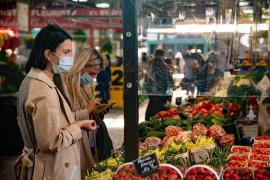 O femeie cu mască de protecție face cumpărături într-o piață agroalimentară