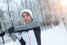 O tânără își face încălzirea pentru o sesiune de sport, în timpul iernii