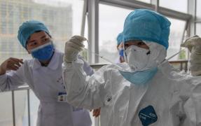 Medici în costume de protecţie contra coronavirusului