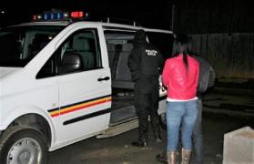 Poliţiştii conduc la maşină o tânără