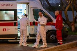 Medici italieni discutând lângă o ambulanţă