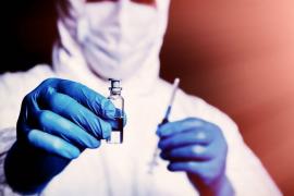 Un medic ţine în mână o fiolă