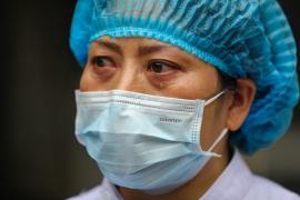 Medic cu lacrimi în ochi, în costum de protecţie împotriva coronavirusului