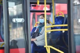 O doamnă circulă cu autobuzul, cu masca pe figură