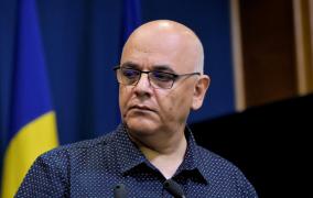 Raed Arafat privește către premierul care face declarații de presă