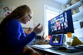 O profesoară ține cursuri online cu elevii ei