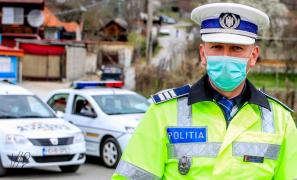 Un polițist cu mască de protecție veghează la respectarea ordonanțelor militare
