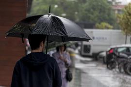 Tânăr cu umbrela pe ploaie în Timișoara