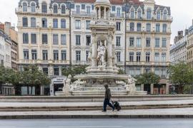 Tânăr cu bagaj în mâină merge pe stradă în Lyon