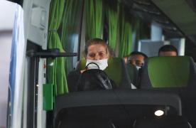 Muncitori români fac cu mâna dintr-un autocar