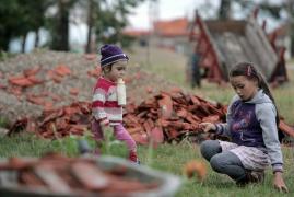 Doi copii se joaca printre resturile unui acoperis smuls de o furtuna, în Timis