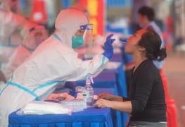 O femeie este testată pentru COVID-19 în Dongxihu District din Wuhan