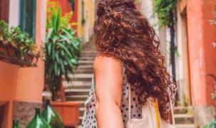 Tânără cu spatele, cu pălărie de soare, în vacanţă