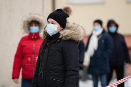 Oameni pe stradă purtând mască