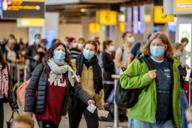 Oameni cu măști pe Aeroportul Schipol din Amsterdam