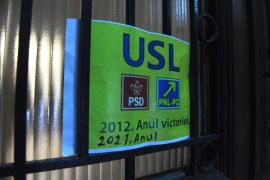 Un afis, lipit pe usa de la intrarea in sediul PNL din Bucuresti de protestatarul Marian Morosanu, cunoscut ca ,,Ceausescu