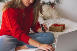 O femeie face cumpărături online pe laptop