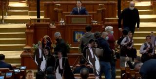 Scandal în Parlamentul României, la discursul premierului Cîţu. Opoziţia i-a adus o coasă şi siluete decupate din carton