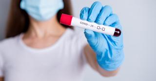 O femeie ţine o probă de test pentru Covid-19