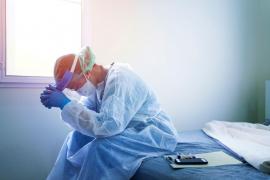 Un doctor în costum de protecţie pare extenuat şi măcinat de lupta împotriva Covid-19