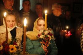 Fetiţă cu flori, ţinând o lumânare aprinsă în Biserică