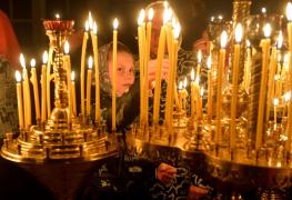 Fetiţă care aprinde o lumânare