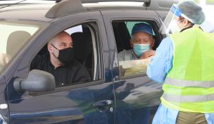 Doi bărbaţi se vaccineayă la drive thru+ul din Bucureşti