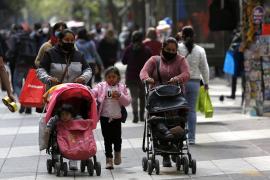 Mai multe mame purtând măști de protecție își plimbă copiii în centrul orașului Santiago, Chile