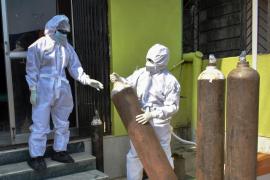 Medici în costum de protecţie transportă recipiente de oxigen în spital