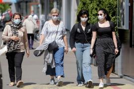 Mai multe persoane cu măşti de protecţie covid se plimbă pe stradă, în Bucureşti