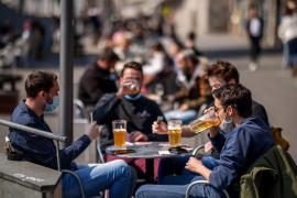 Tineri care se bucură de o bere și joacă cărți în timp ce terasele au fost redeschise