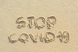 Mesaj Stop Covid-19 scris pe nisip