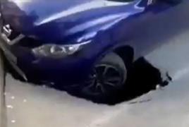 Mașină, la un pas de a fi înghițită de asfalt pe un bulevard din Craiova. Autoturismul a rămas suspendat cu roata din faţă deasupra gropii