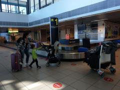 O femeie cu mască pe față este însoțită de doi copii, pe Aeroportul Internațional Henri Coandă Otopeni