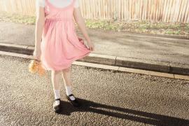 O fetitța pozează cu o păpusa