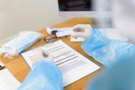 Test rapid de Covid şi un doctor care notează rezultatul