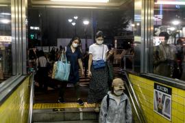 Japonezi fotografiaţi la intrarea într-o staţie de metrou din Tokyo
